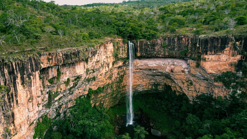 a large waterfall is in a big open ravine