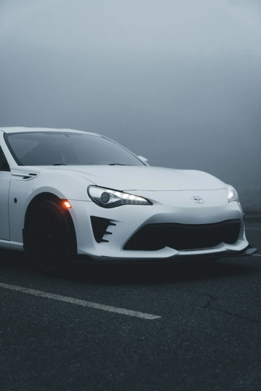 white car parked in a parking lot with foggy background