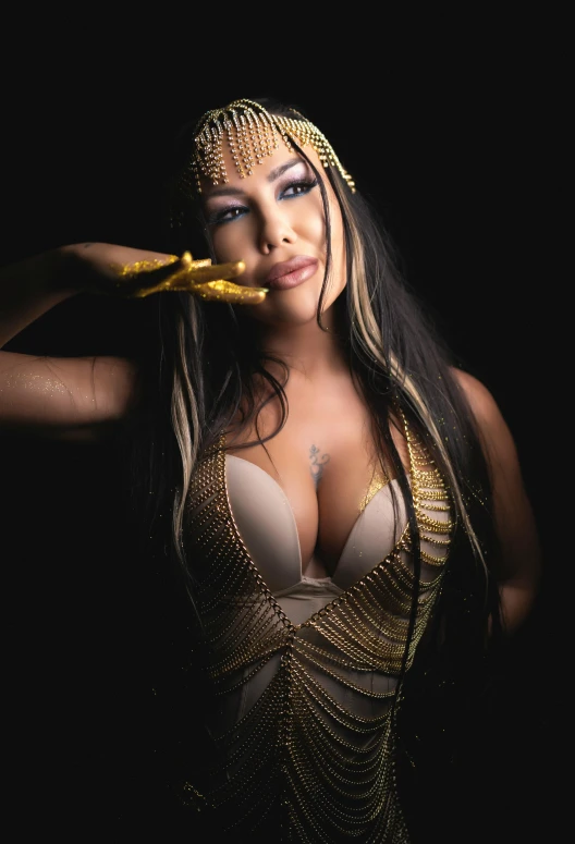 a woman is wearing gold and posing