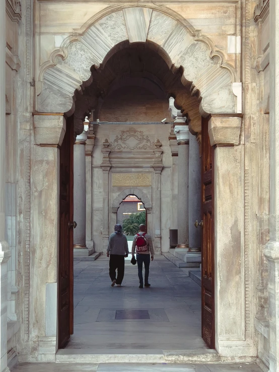 people are walking under an archway in a building