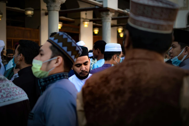 many men stand close together wearing colorful clothing