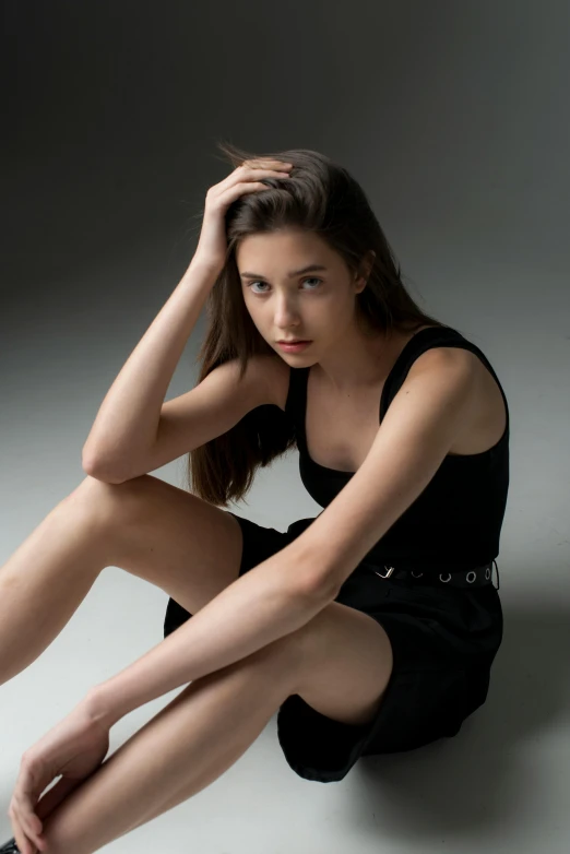 a young woman sitting on the floor with her legs crossed