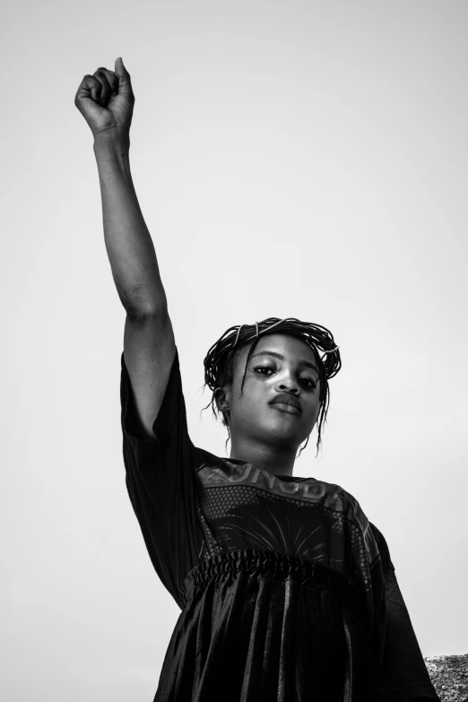 a black woman holding a kite high up in the air