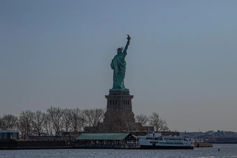 a statue stands next to a large body of water