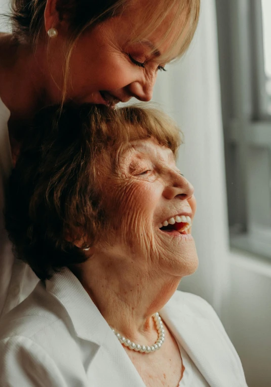 an elderly woman sitting with a young woman