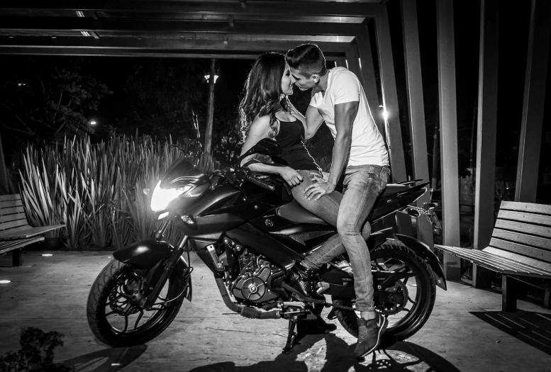 a couple kissing while sitting on a motorcycle