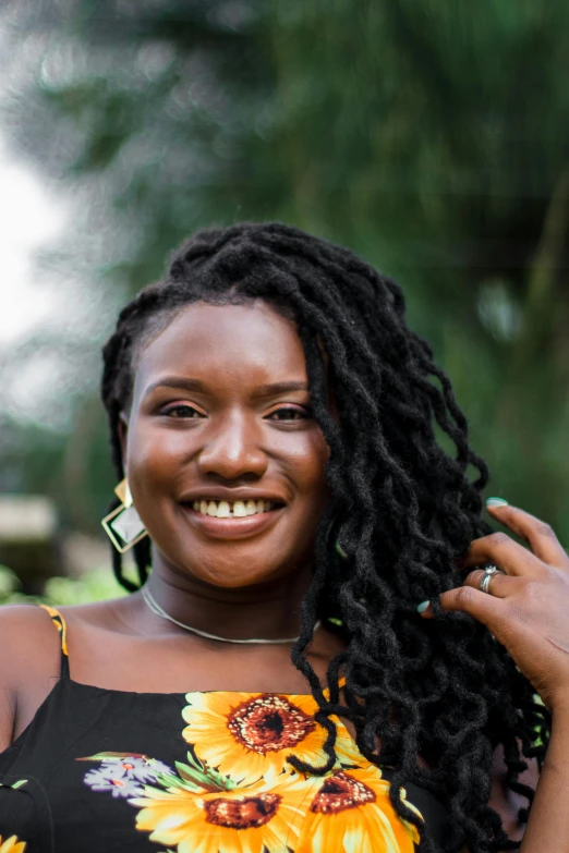 an african american woman with dreadlocks smiles at the camera