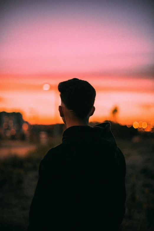 a person in the distance looking at a sunset