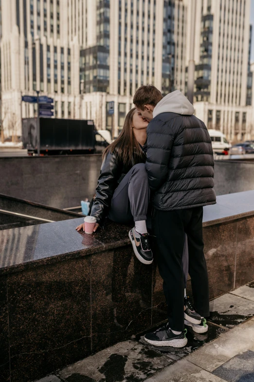 a  is leaning on the ledge kissing his little girl