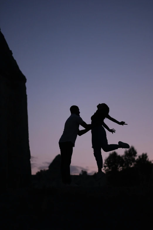 two people are dancing with each other in the dark