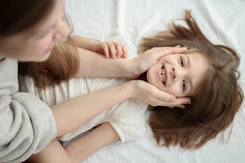 two young children are smiling while they lie down
