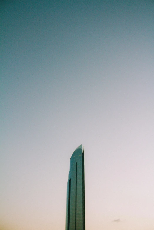 a tall building is silhouetted against a clear sky