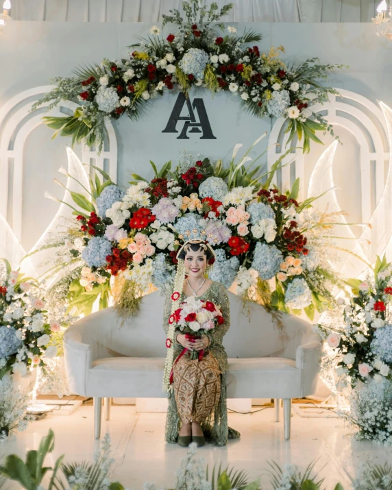 a woman holding several different flowers sitting on a couch