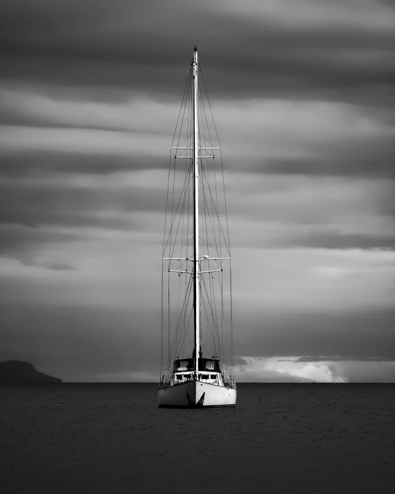 a sailboat is in the water under the cloudy sky