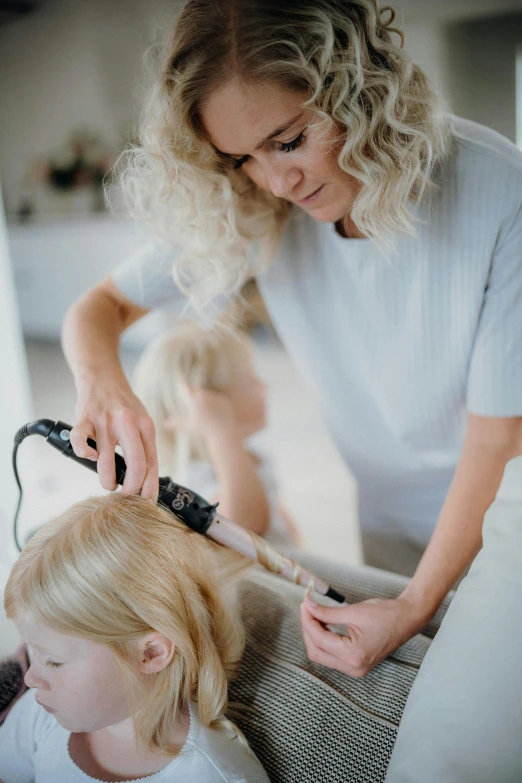 a women who is blow drying another woman's hair