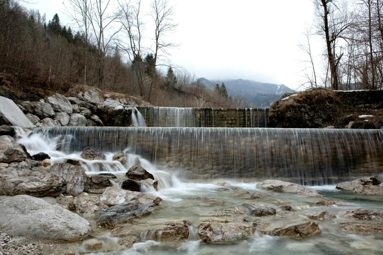 a small waterfall with two falls next to some rocks