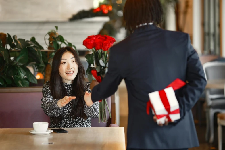 a woman sitting at a table talking to another woman