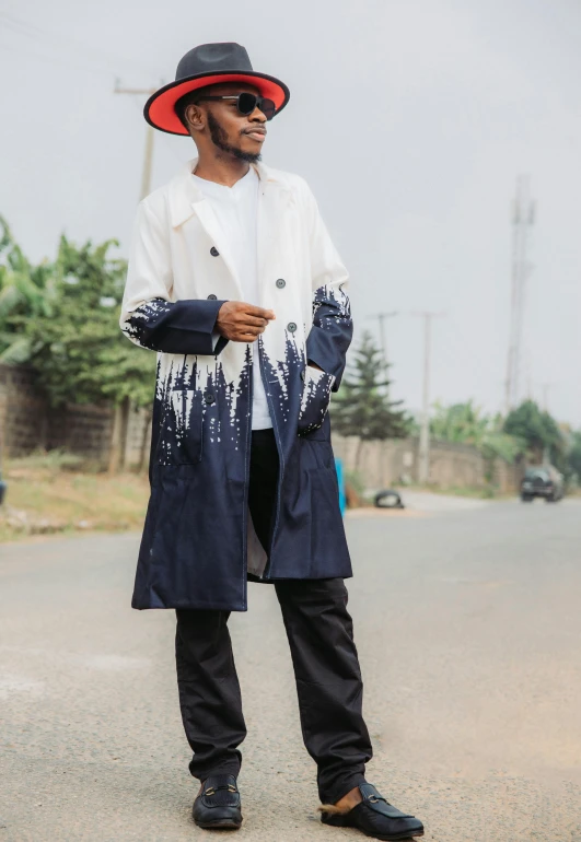 a man wearing a hat and coat on the street