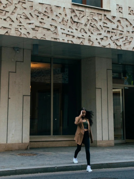 a woman is walking down a sidewalk with a cell phone in her hand