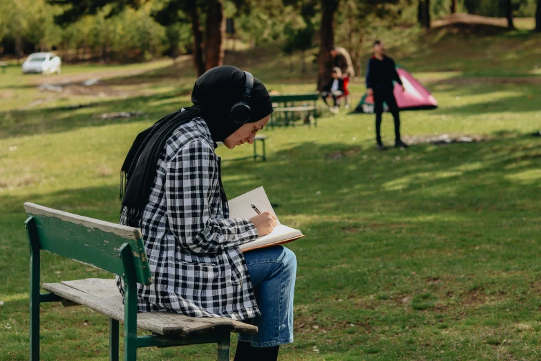 a person sitting on a bench with books in their hands