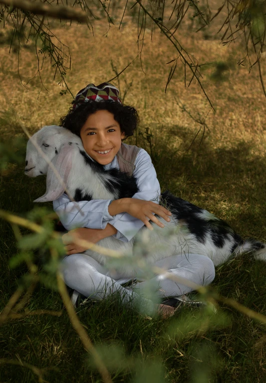 a  sitting in the grass holding her stuffed animal