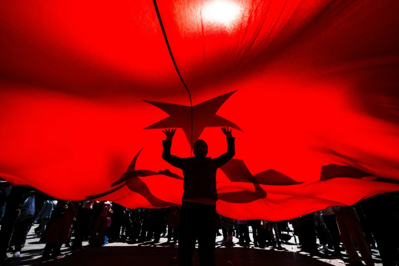 person with red and black shadow over red cloth