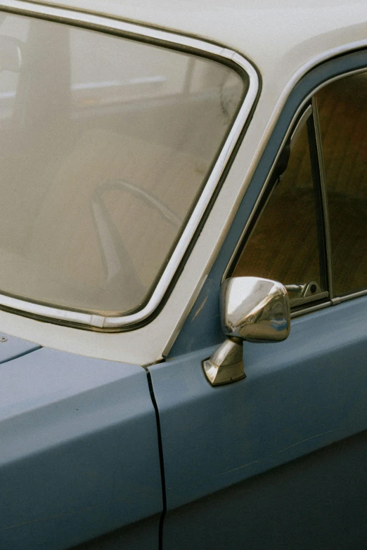 the window side mirror on a small blue car