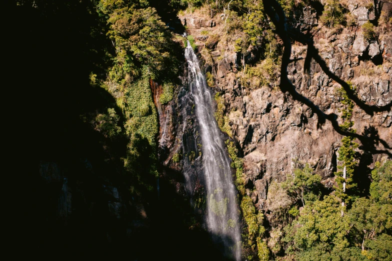 a large waterfall in a rocky valley surrounded by trees