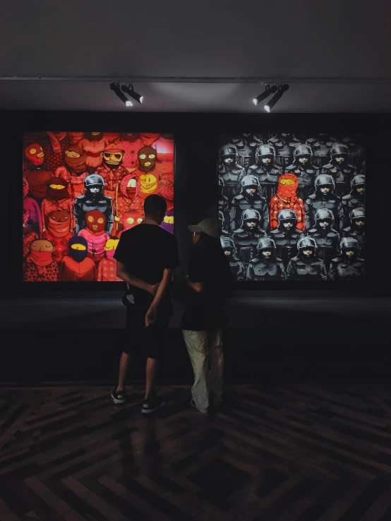 a man and woman looking at two paintings on display