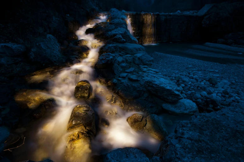 a stream of water near rocks in the night