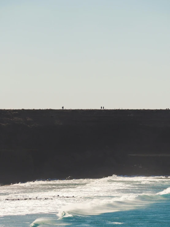 a lone person on a surfboard in the middle of the water