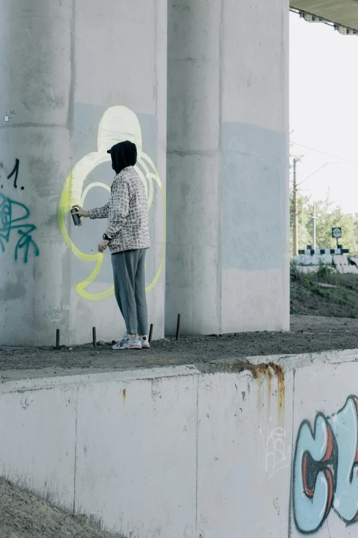 a person spray painting on the concrete of a wall