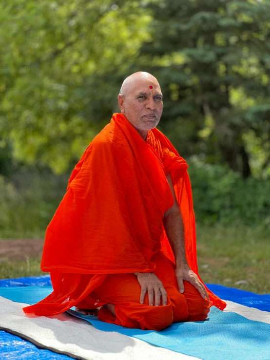 an old man sitting on top of a blanket