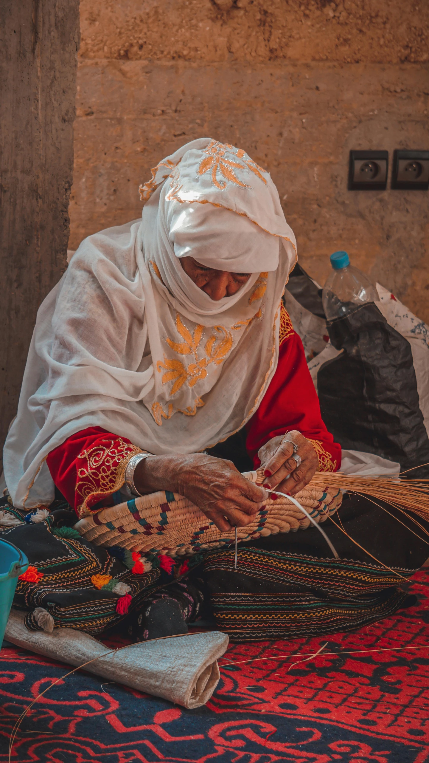 a woman in white veil with jewelry sitting on the floor