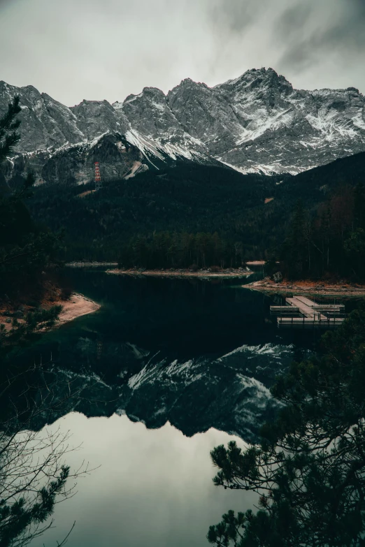 a small lake surrounded by snow covered mountains