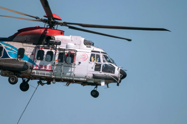 a helicopter flying against a blue sky