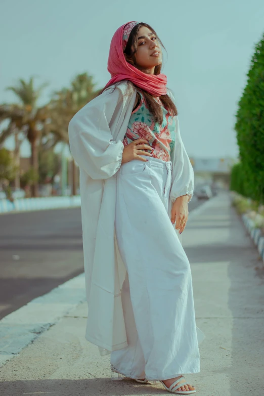 a woman wearing a scarf standing on a street