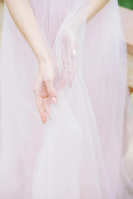 a person wearing a pink dress holding a white object