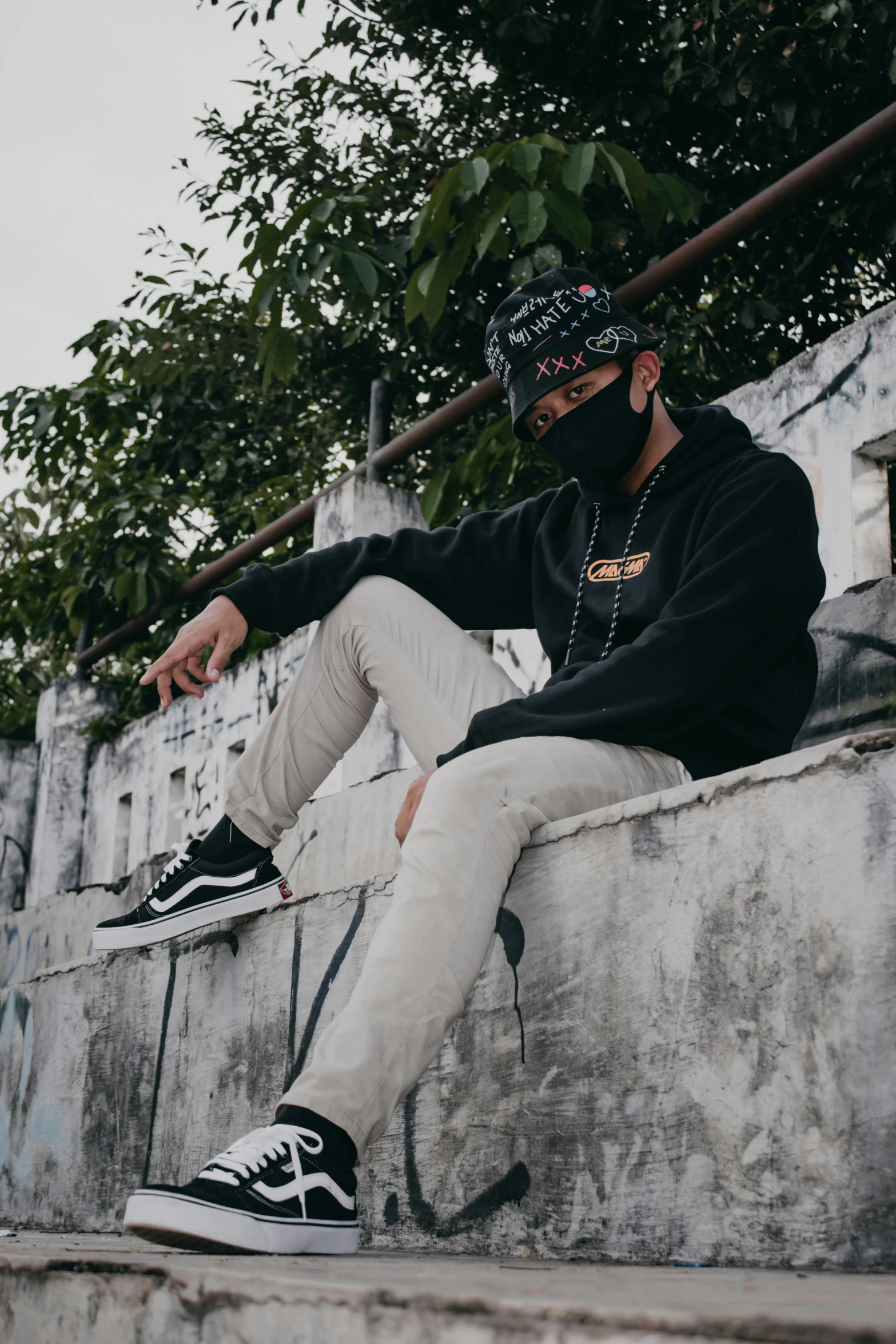 a man sits on the ledge of a cement wall