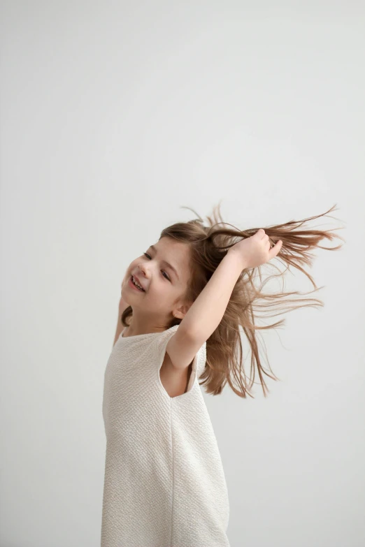 a girl is holding her hair back while she flies through the air