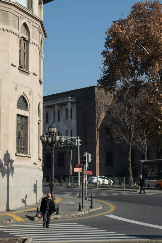 an intersection with people walking across it on a sunny day