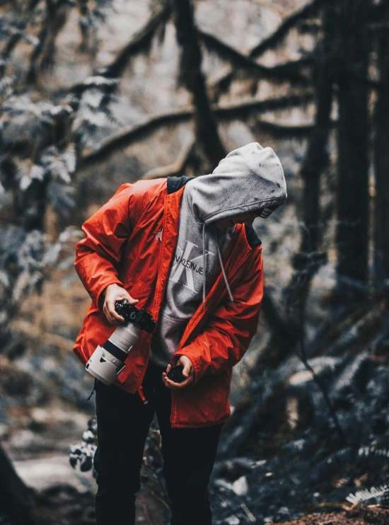 a man is standing outside wearing a red jacket and backpack