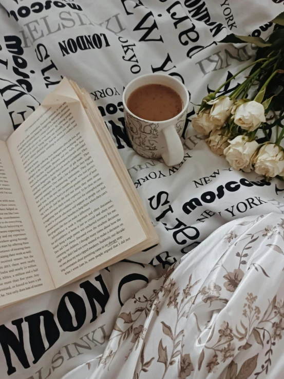 an open book and flowers are on the bed