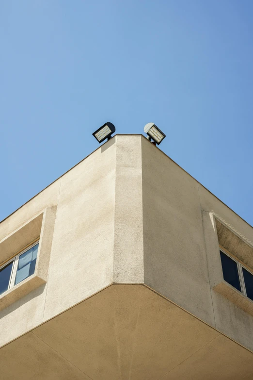 the top of an apartment building with two surveillance cameras on the roof