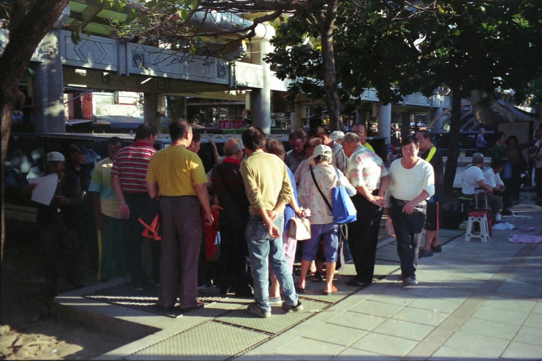 a group of people standing at a bus stop