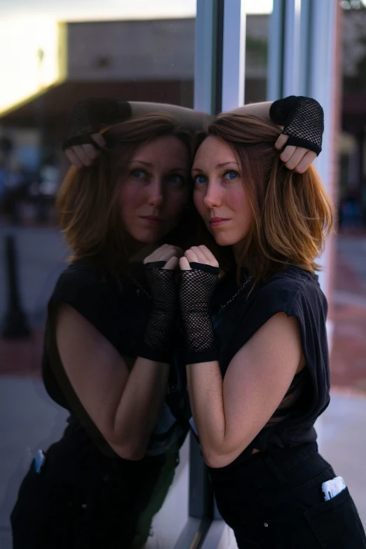 two beautiful young women leaning against a building