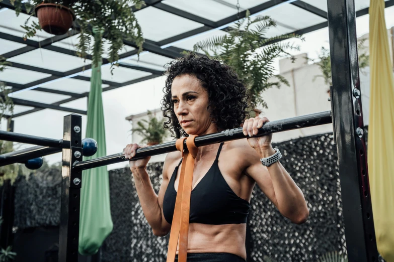 woman wearing black  and gold tie lifting bar