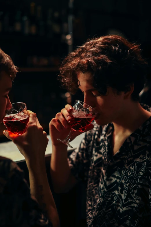 two woman drinking wine in a dimly lit room