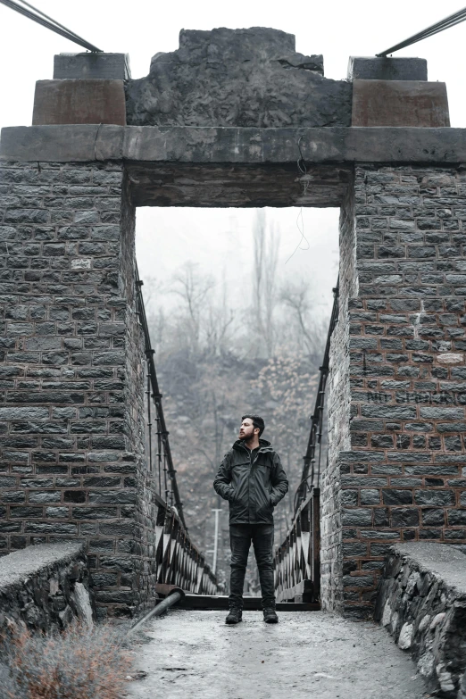 the man is standing on the bridge in the winter