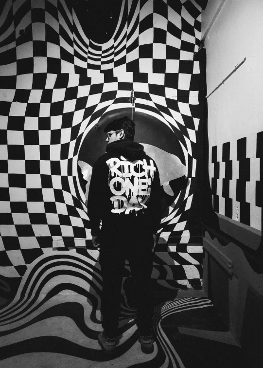 a person standing in front of some checkered wallpaper